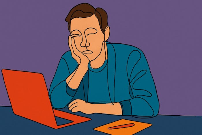 A man is bored at his laptop.