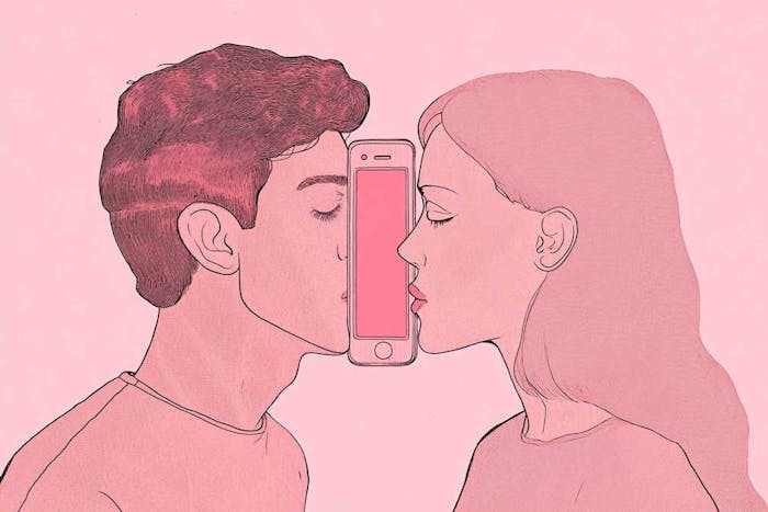 A man and a woman try to kiss with a phone between their faces